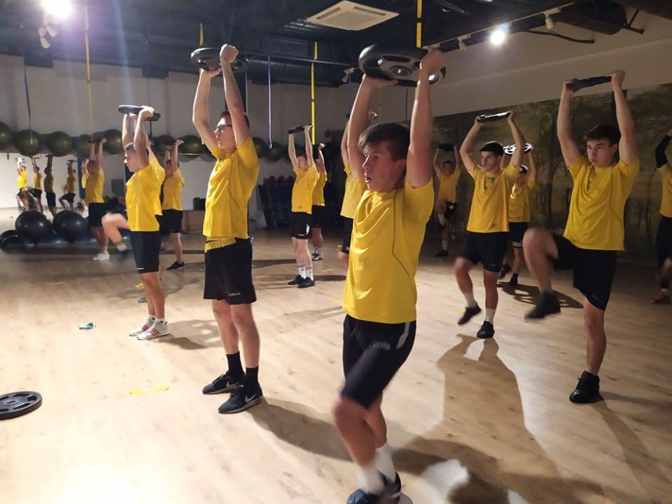 Uczestnicy treningu z obciążeniem w formie talerzy